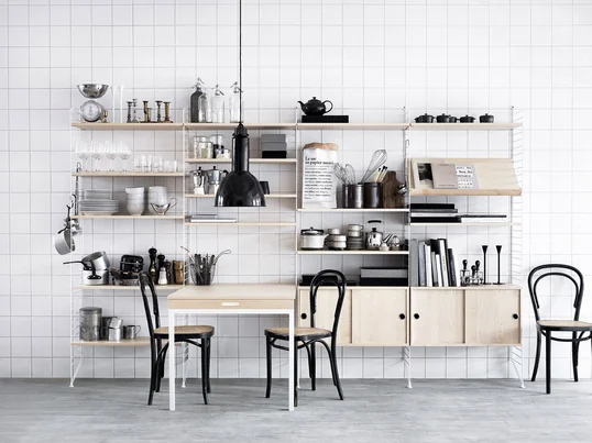 Das Regal-System von String in Weiß und aus Holz passt in jede Küche. Es ist flexibel erweiterbar und passt sich Ihrem Interieur an. Die Schränke sorgen für optische Ordnung.