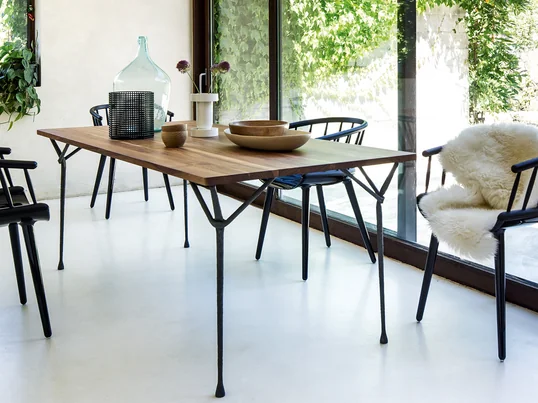 Der Officina Esstisch von Magis hat genau die richtige Größe für das Ess- oder Wohnzimmer. Accessoires wie Vasen und Schalen vervollständigen das heimelige Bild des Tisches.