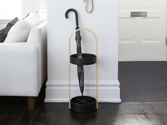 Der Hub Regenschirmständer von Umbra in der Ambienteansicht: Stockschirme lassen sich bequem im Hub Regenschirmständer abstellen, während kleine Taschenschirme am Hub Wandhaken befestigt werden und abtropfen können.