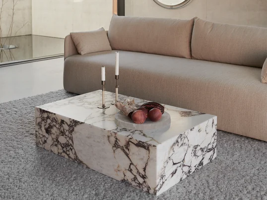 Plinth Couchtisch low, rose von Audo in der Ambienteansicht. Der Couchtisch aus Marmor wirkt besonders edel und zeichnet sich durch sein kontrastreiches Design aus.
