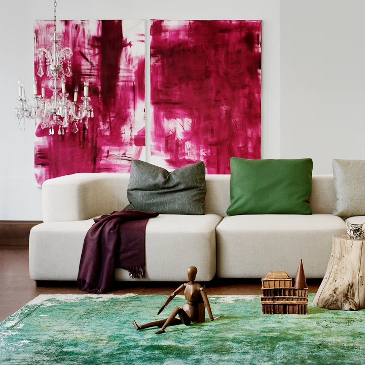 Das Alphabet Modulsofa von Fritz Hansen vor einem grünen Teppich und in Kombination mit abstrakten Kunstwerken