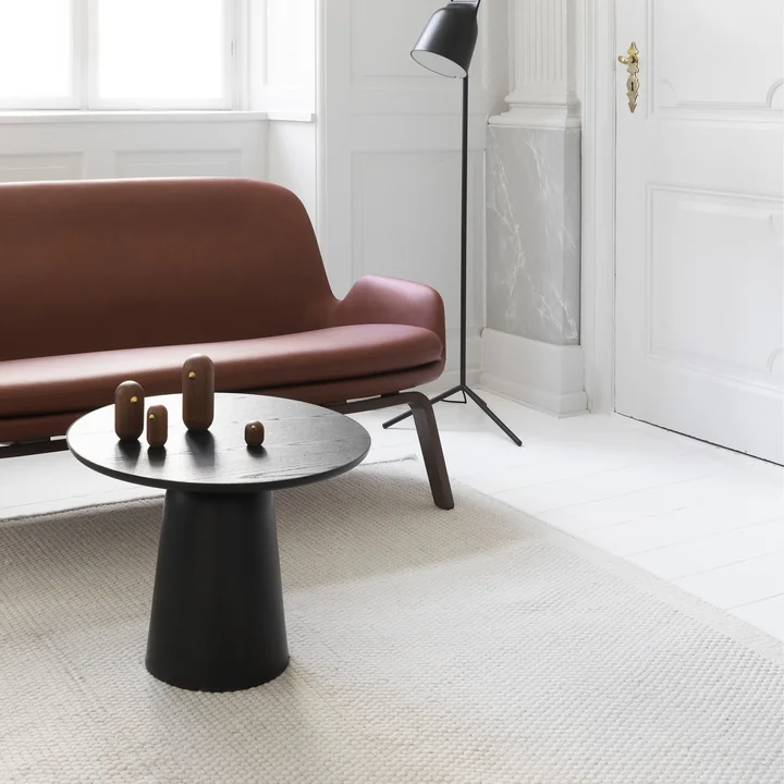 Der Turn Couchtisch von Normann Copenhagen vor einem Ledersofa in einem hellen Wohnbereich