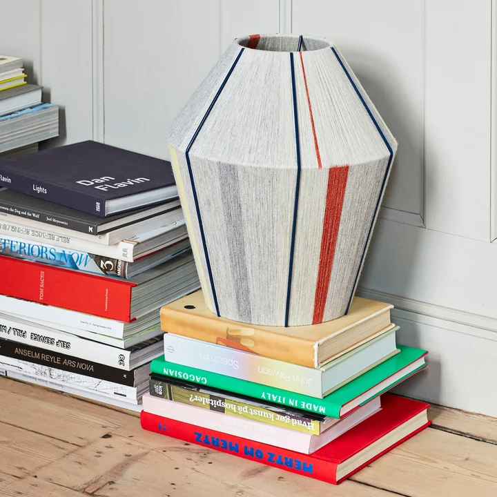 Der Bonbon Lampenschirm von HAY auf einem bunten Bücherstapel