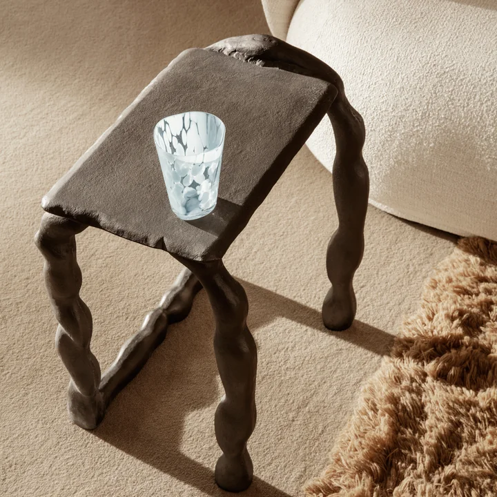 Das Casca Trinkglas von Ferm Living auf dem Rotben Couchtisch