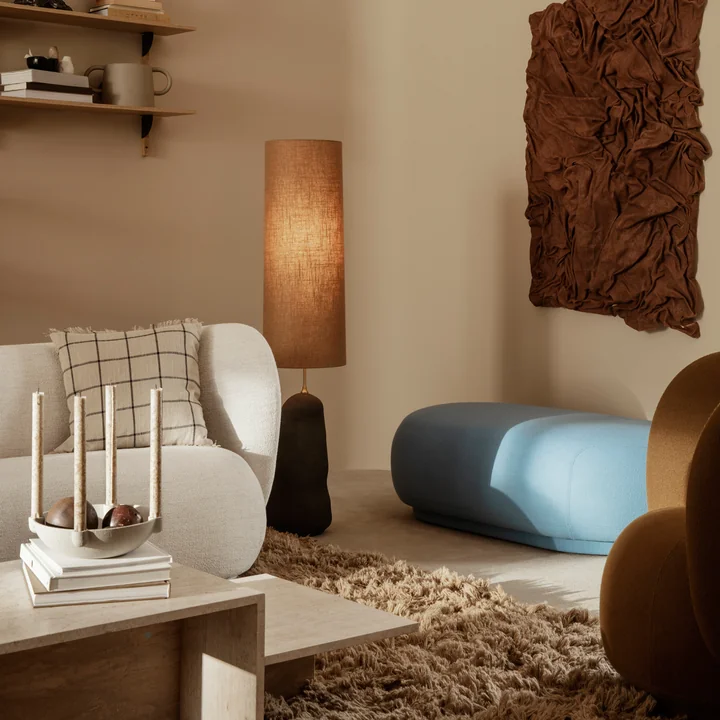 Das Rico Sofa von Ferm Living auf einem braunen Teppich hinter einem Travertin-Couchtisch