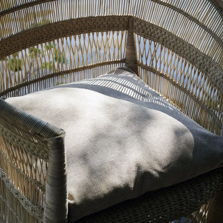 Das Fine Outdoor Kissen von House Doctor in einem geflochtenen Outdoor-Sessel