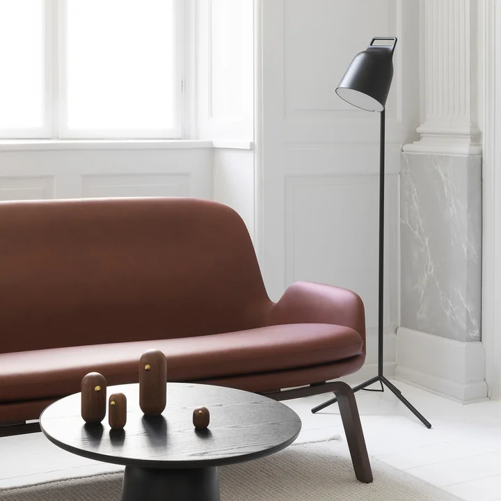 Die Stage LED-Stehleuchte von Normann Copenhagen neben einer braunen Leder-Couch