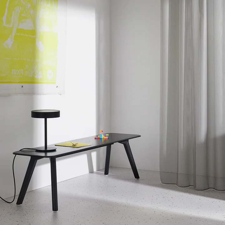 Elegante, schlanke Holzbank als Farbkontrast